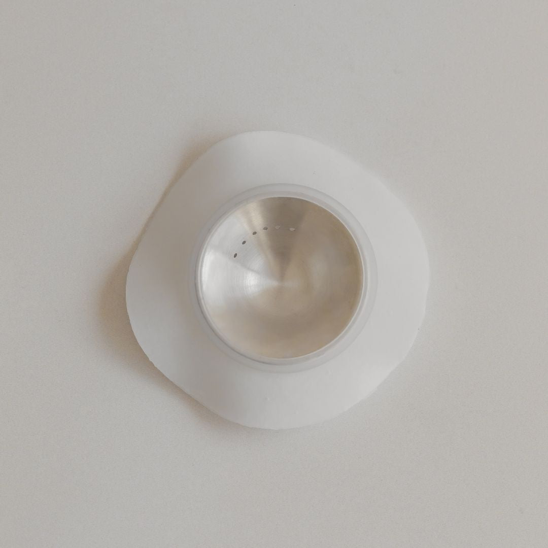 A round, transparent Mammae bosom ritual disc with a white hydrogel adhesive ring on a plain background.