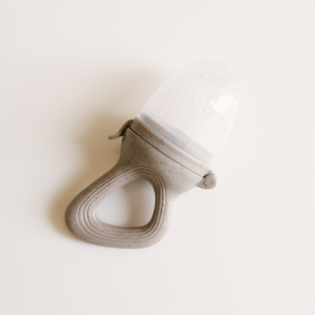 A Dove & Dovelet silicone self feeder in the shade pebble on a white surface.