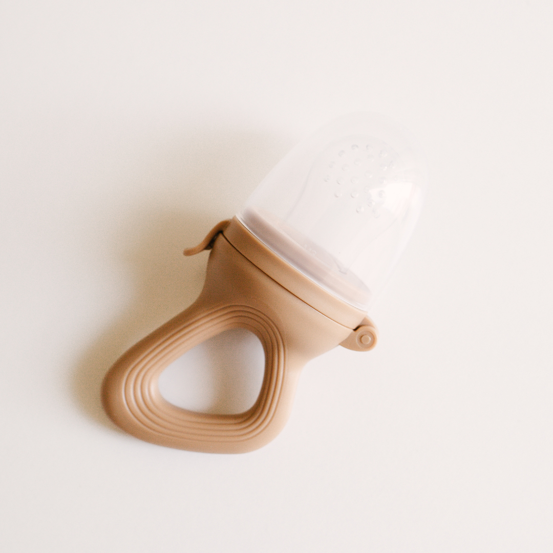 A Dove & Dovelet silicone self feeder in the shade Clay on a white surface.