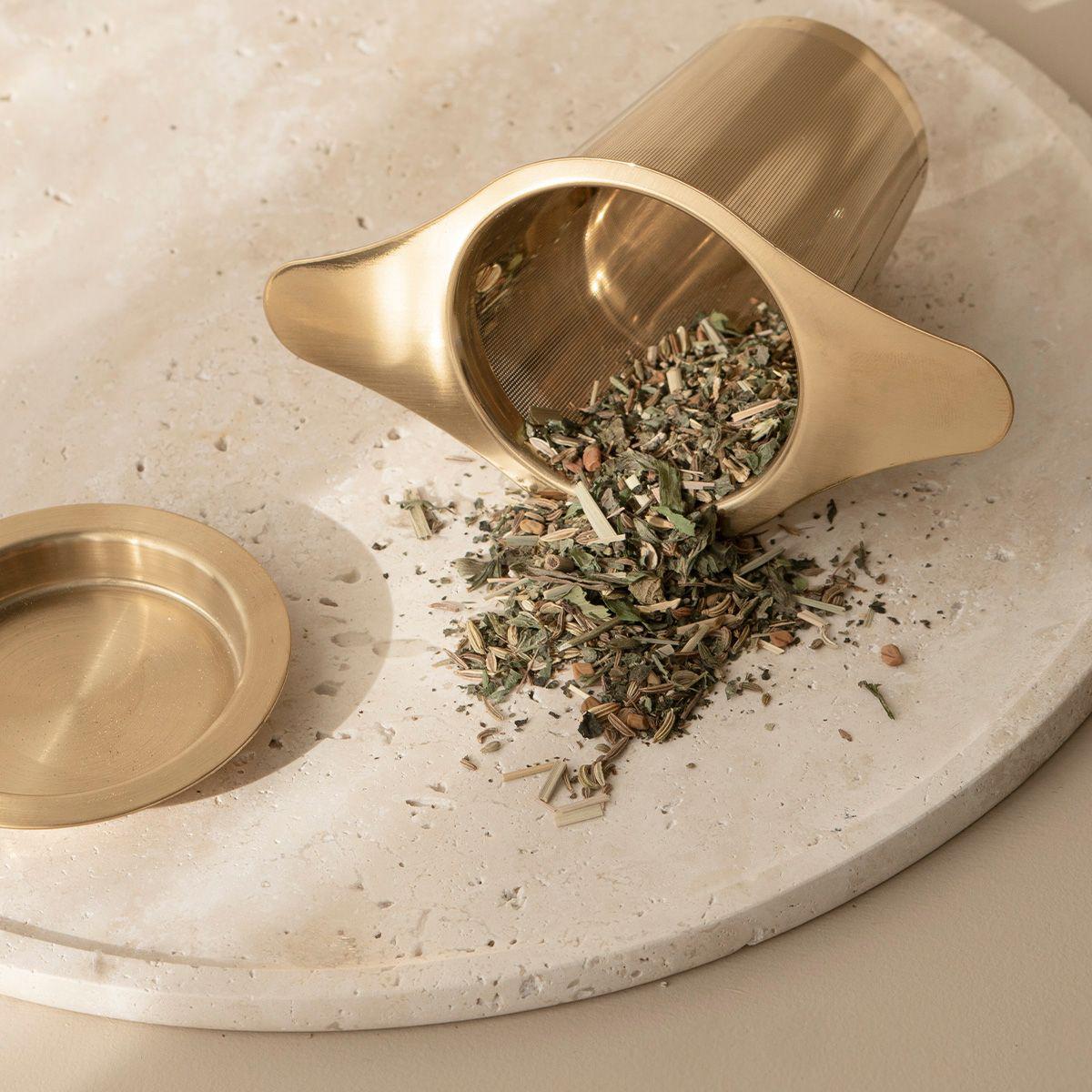 A breastfeeding ritual infusion tea combining herbs for breast care and nursing on a marble tray.