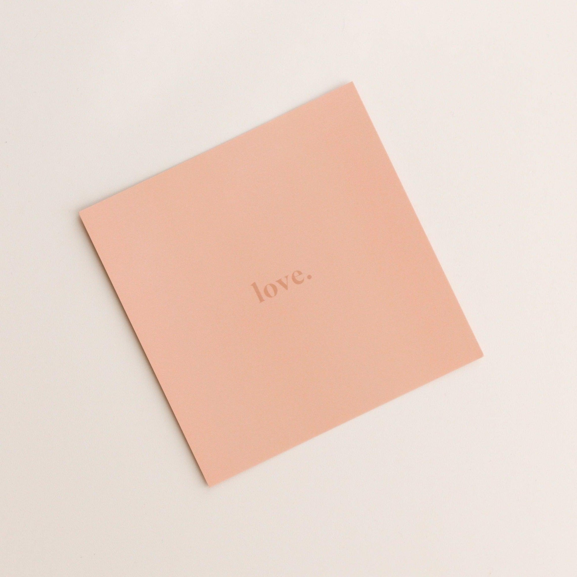 Product Description: The "love | gift card" by biglittlethings. is a square, peach-colored card featuring the word "love." elegantly printed in the center with a minimalist font.