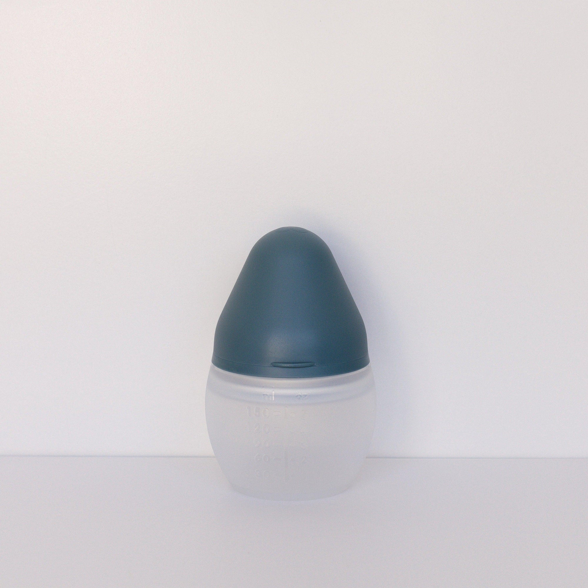 An Elhée France BibRond | blue grey baby bottle sitting on a white surface.