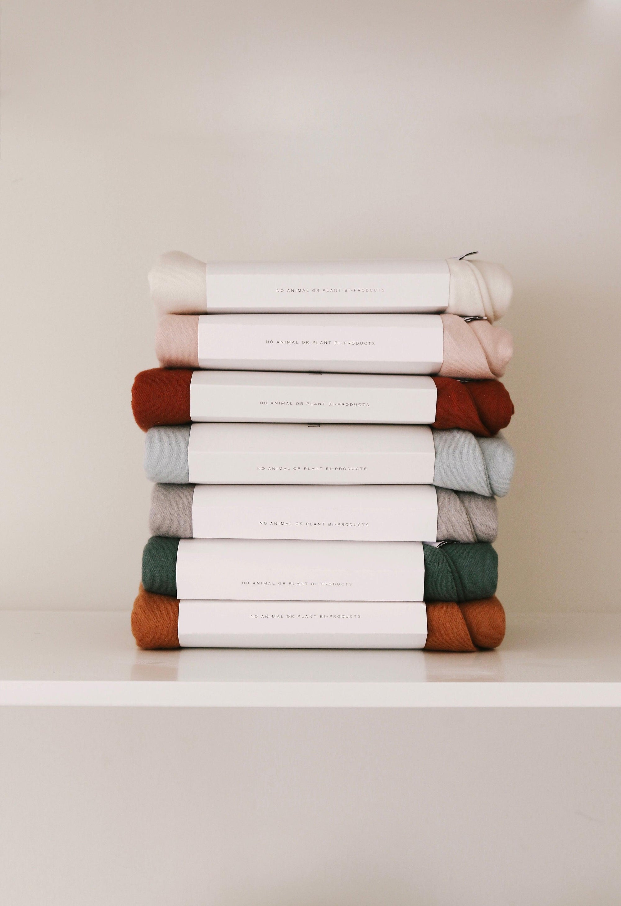 A stack of Snuggle Me Lounger Covers on a shelf.