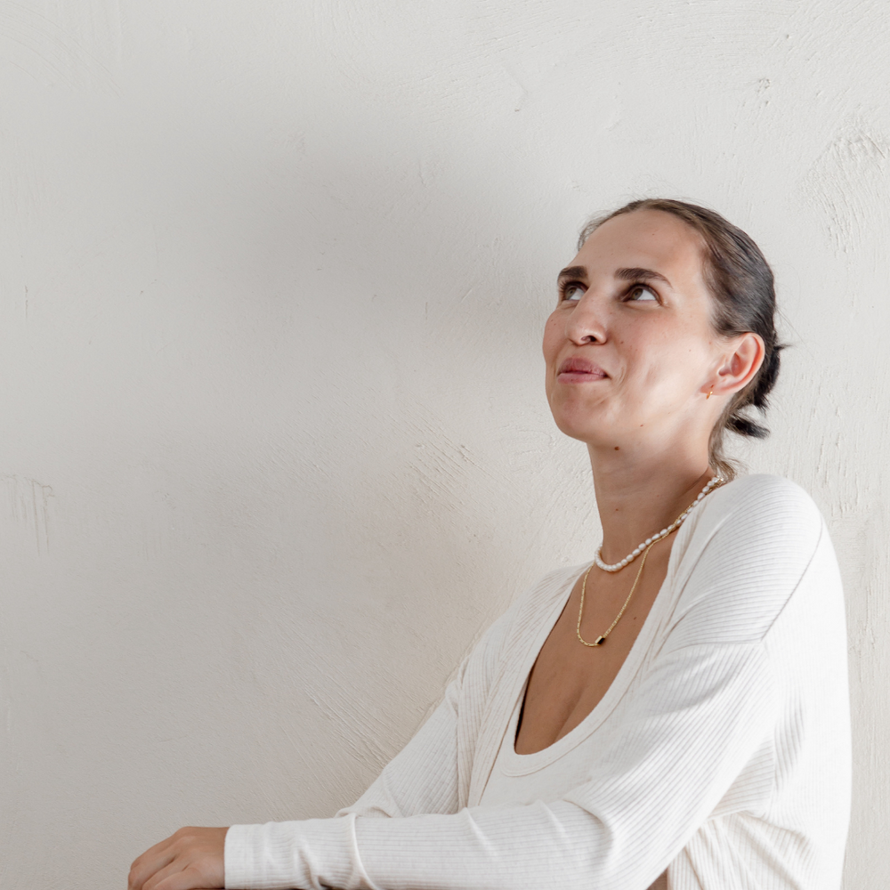 The top half of a new mum as she sits on the toilet and looks up into the corner of the photo. She could be contemplating going to the toilet for the first time after birth. 