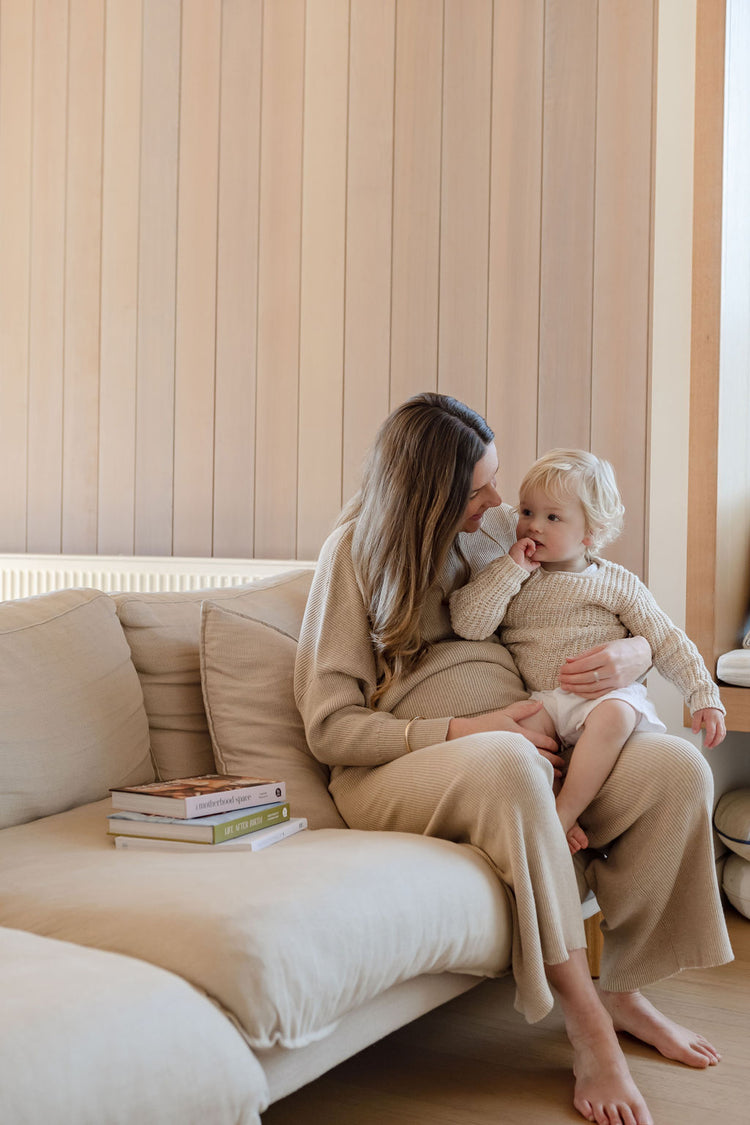 pregnant mother holding her toddler.