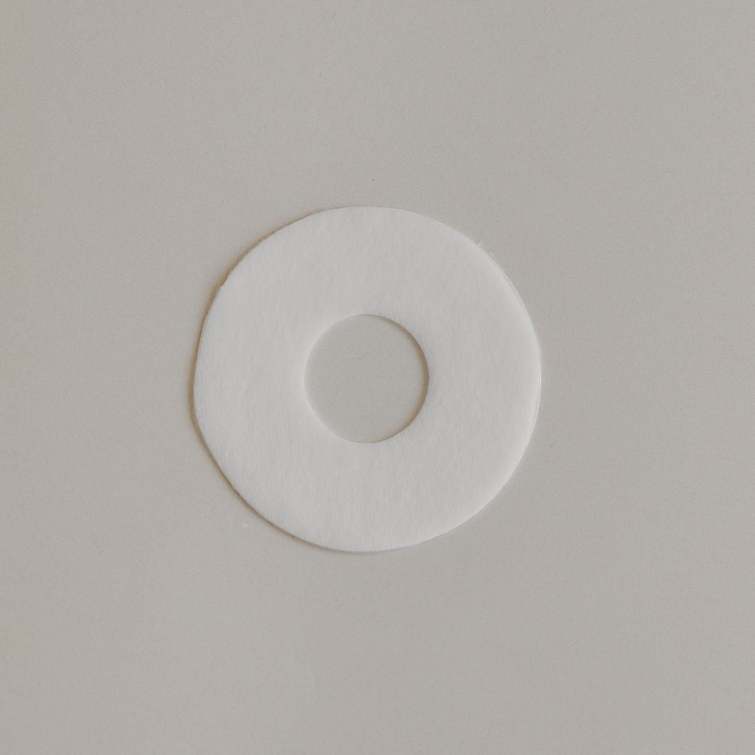 A plain white circular Mammae Bosom Ritual Disc with a smaller circle in the center on a light gray background.