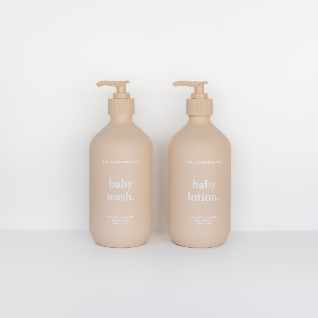 Two bottles of The Commonfolk Collective baby wash & lotion kit, containing natural ingredients, on a white background.