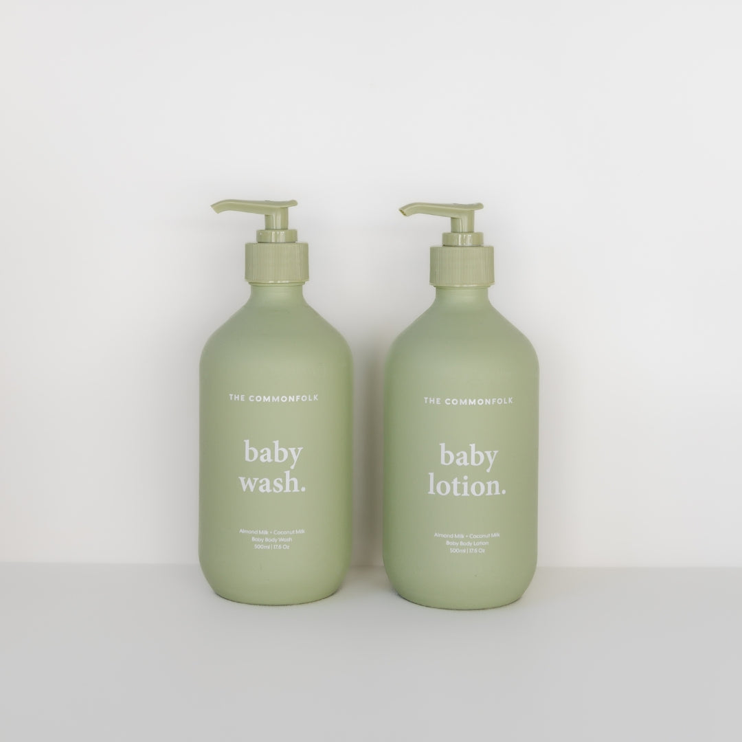 Two bottles of The Commonfolk Collective baby wash & lotion kit in sage with rejuvenating ingredients on a white background.