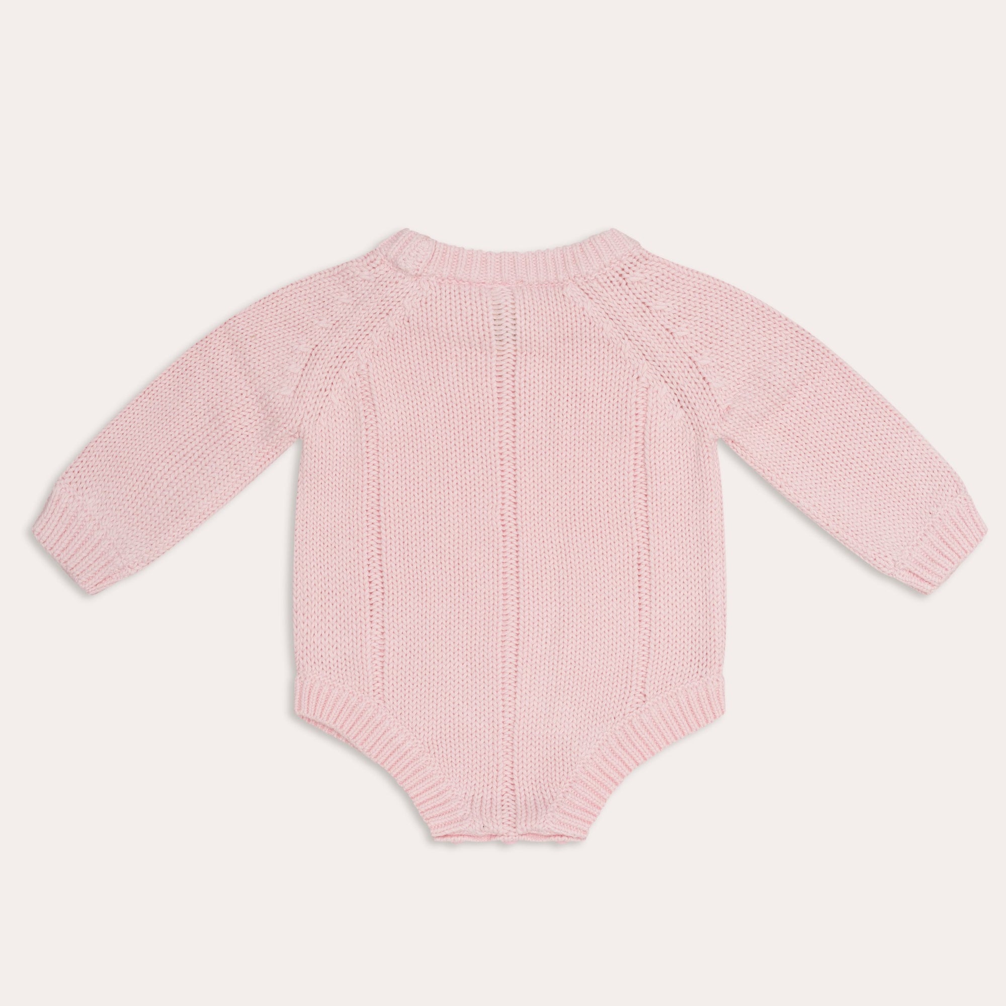 An illoura tallow knit romper in pink by Illoura the Label with ribbed finishings on a white background.
