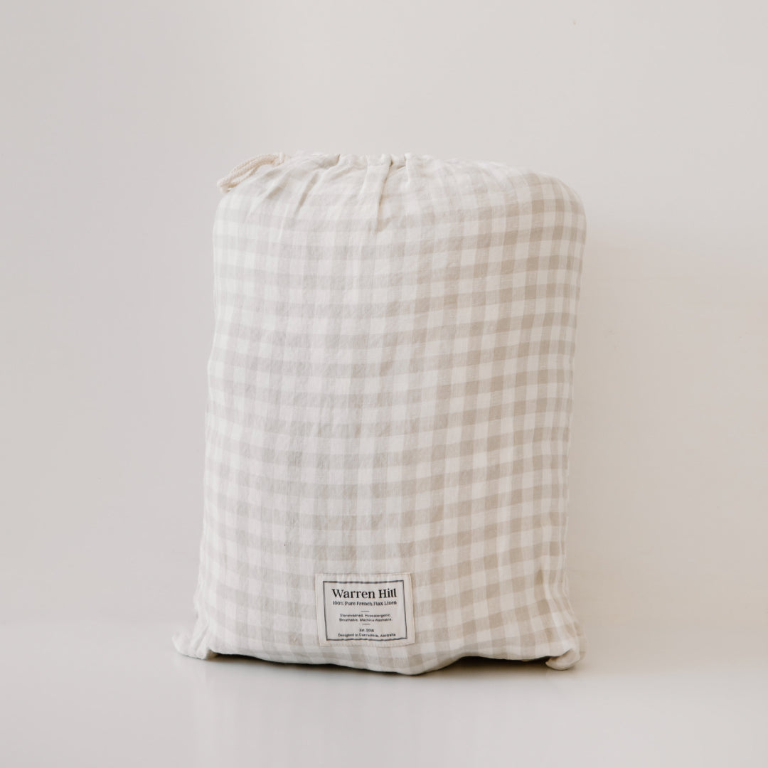 A hypoallergenic gingham fabric bag with a drawstring closure and a "Warren Hill" label attached at the bottom.