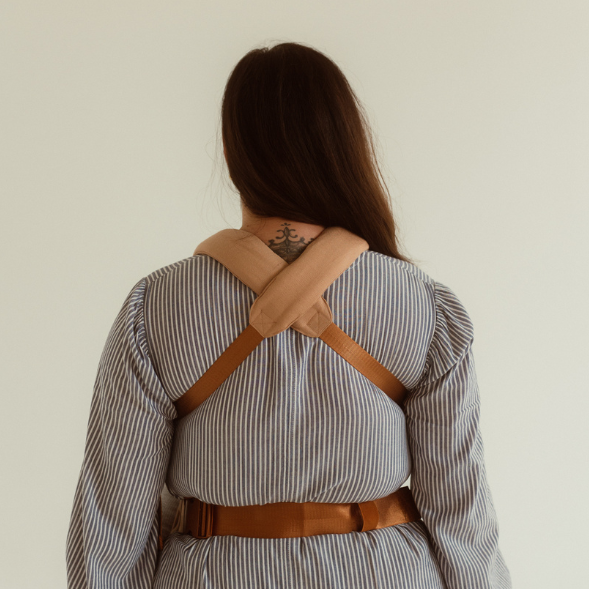 A woman wearing a Cinta Clip Carrier from Chekoh.