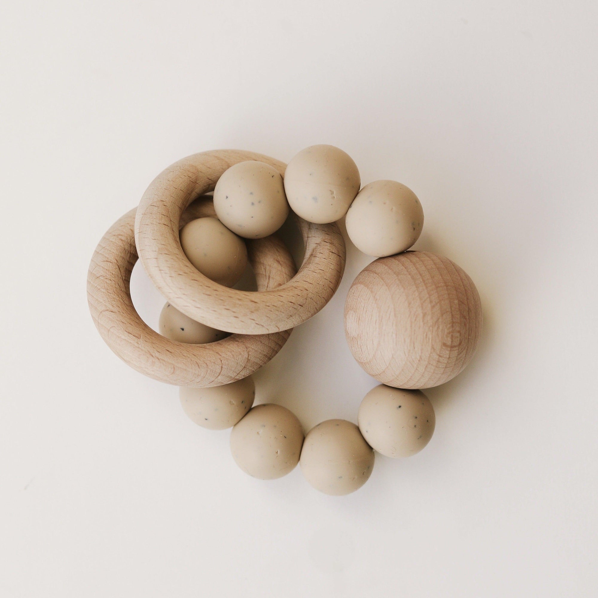 A set of Dove & Dovelet Wooden Silicone Teethers on a white surface.