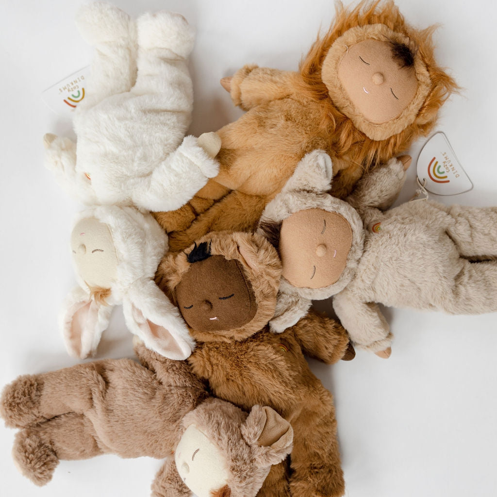 A group of Olli Ella cozy dinkums | mousy pickle stuffed animals laying on a white surface.