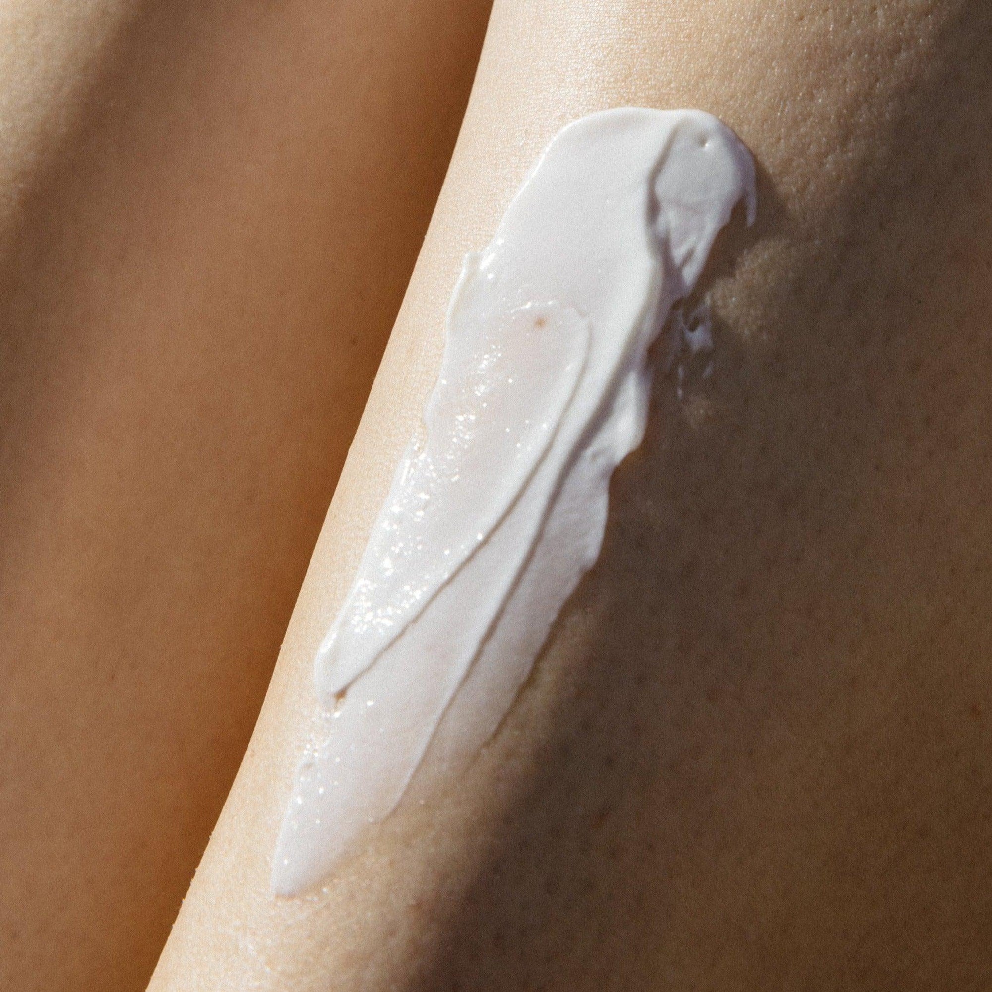 A close up of a woman's leg with Wiley Body's Everything Lotion to hydrate the skin.