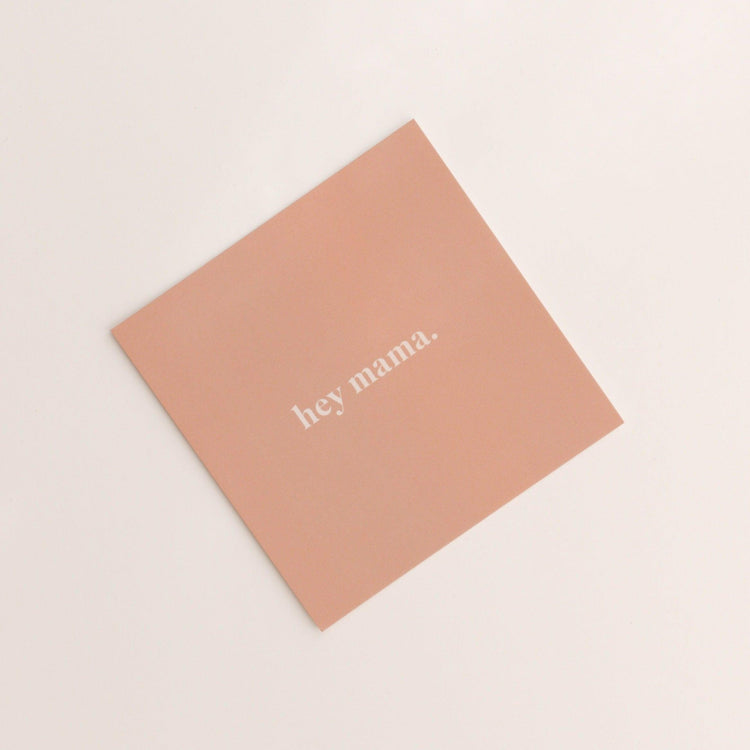 A square, peach-colored "hey mama | gift card" from biglittlethings. features the text "hey mama." in lowercase white letters on a light background.