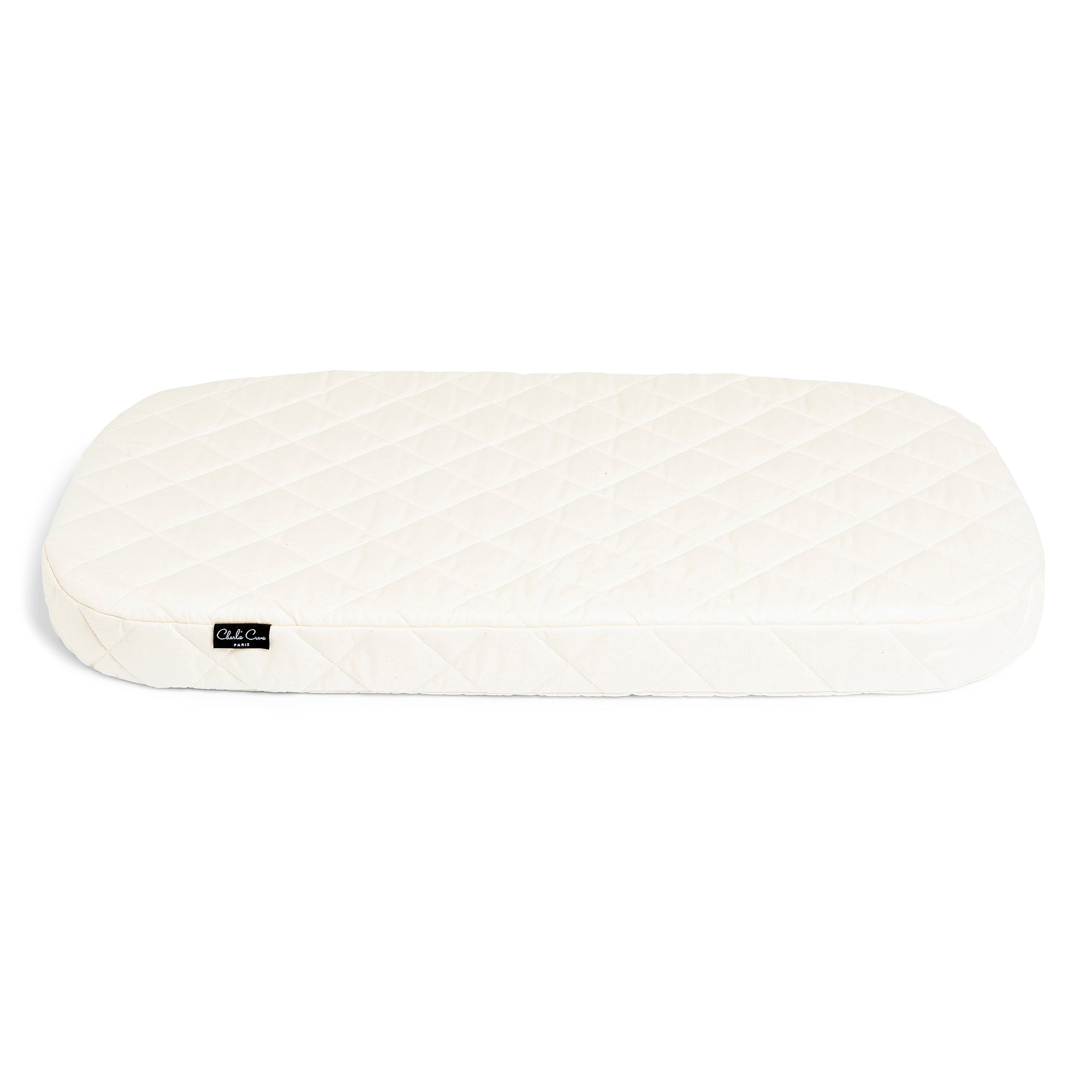 A white Charlie Crane quilted bassinet mattress for KUMI Bassinet. 