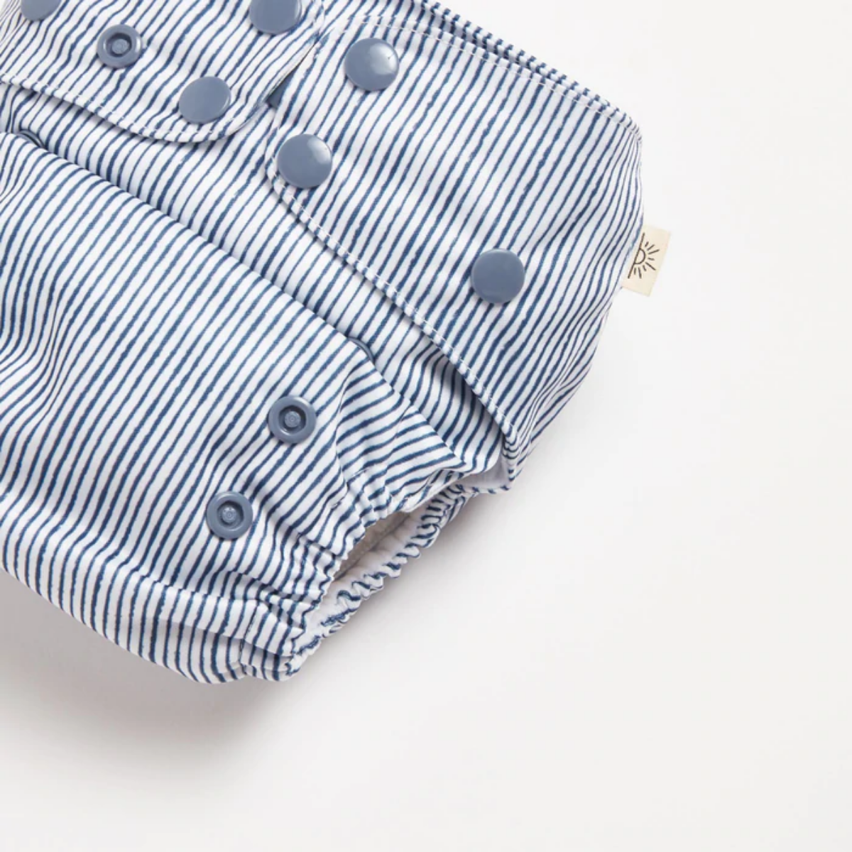 A close up of Indigo Pinstripe 2.0 Modern Cloth Nappy by EcoNaps on a white background.