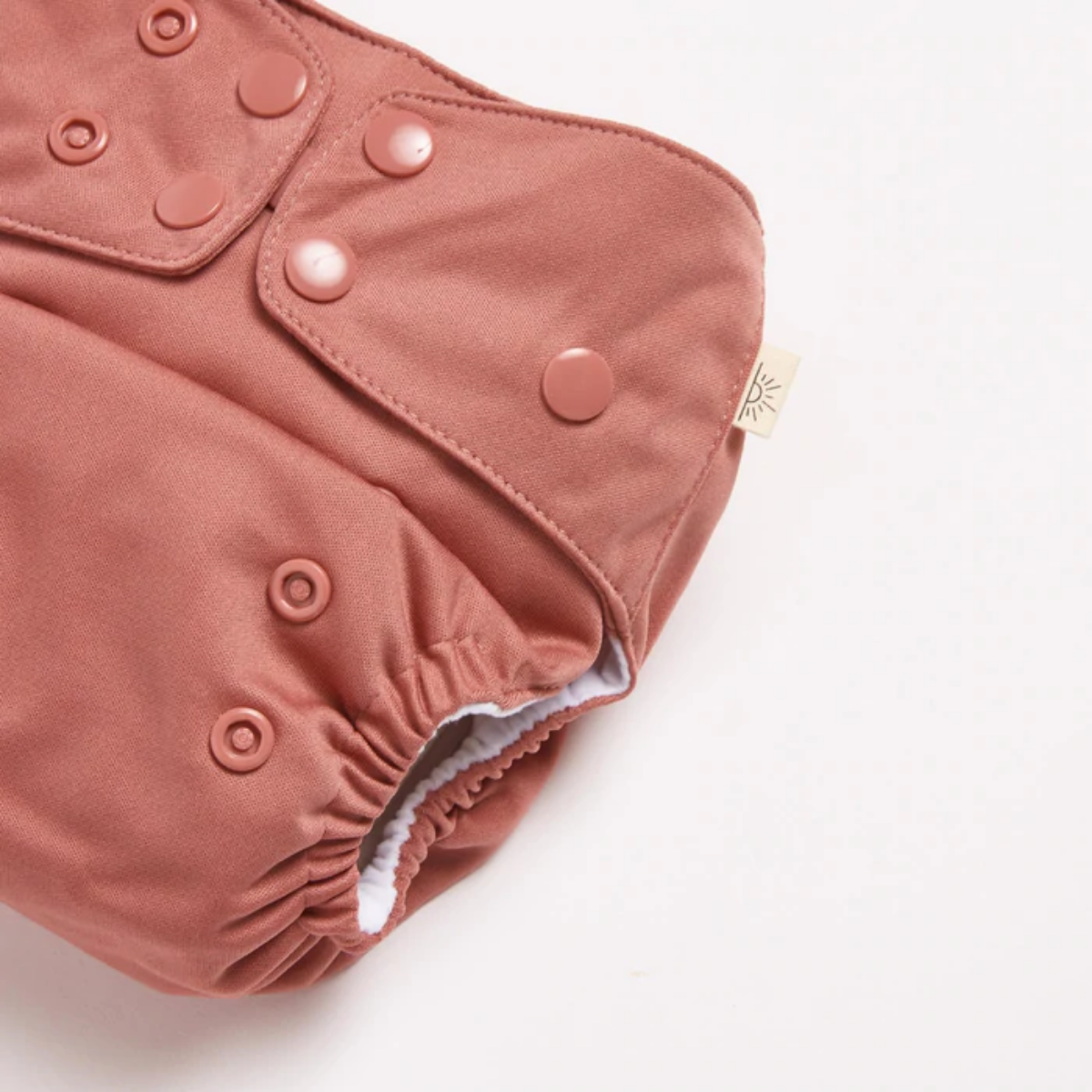 A close up of Terracotta 2.0 Modern Cloth Nappy by EcoNaps on a white surface.