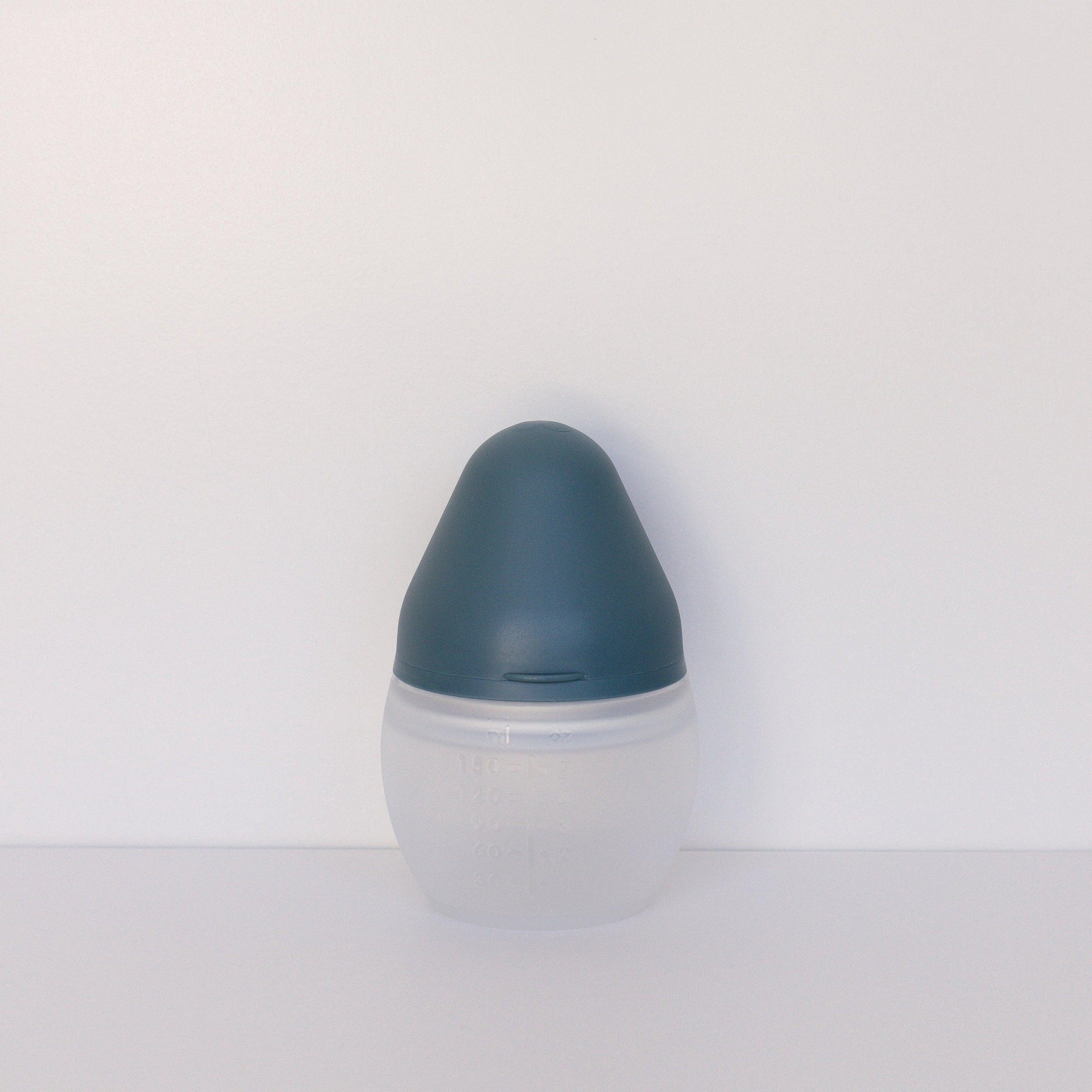 An Elhée France BibRond | blue grey baby bottle sitting on a white surface.