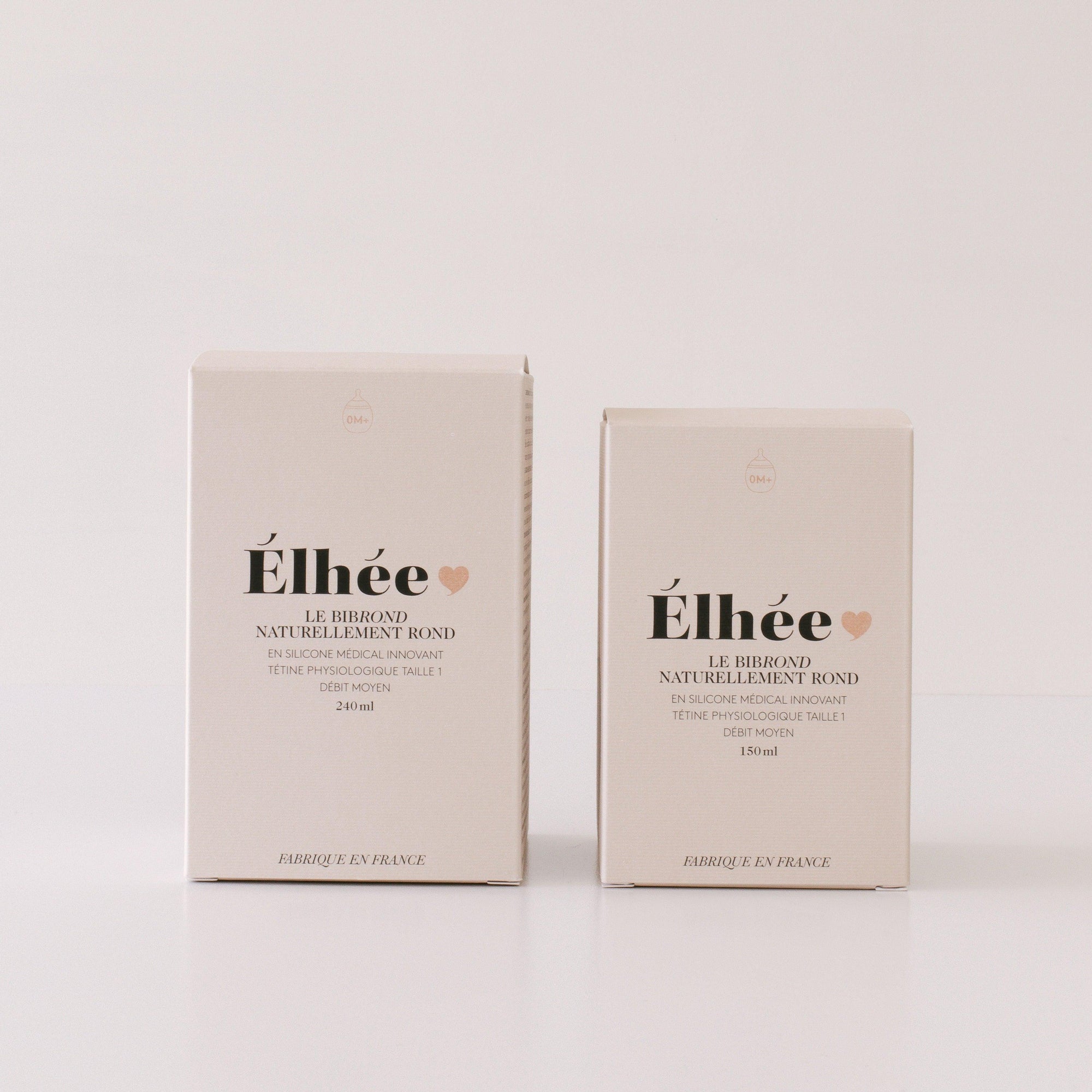 Two boxes of Elhée France's baby bottles on a white surface.