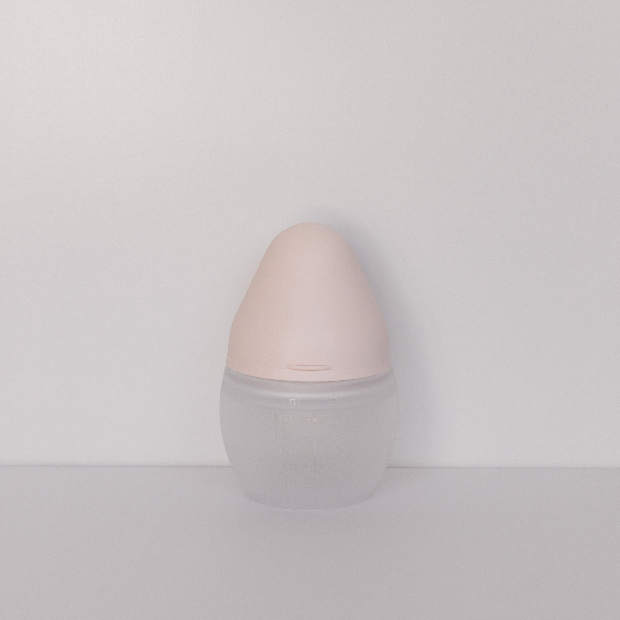 An Elhée France BibRond bottle in the shade nude standing against a white surface.