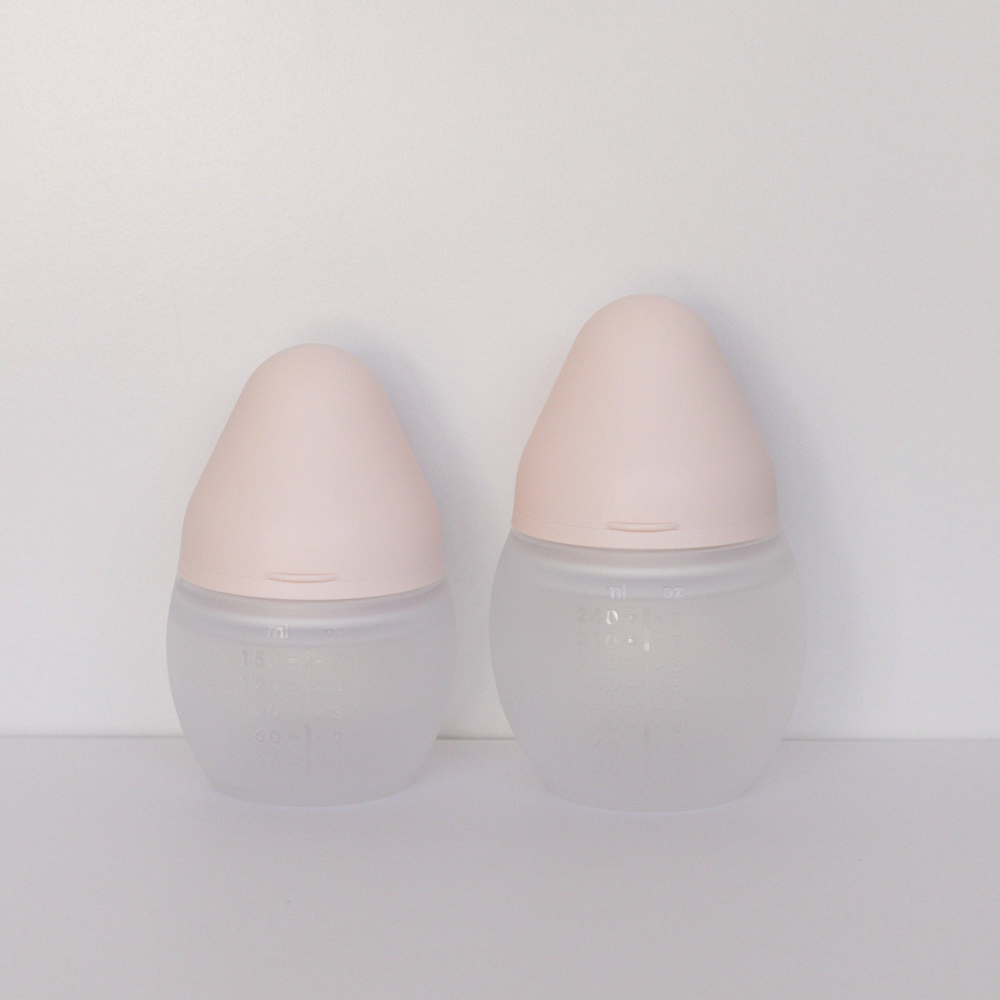Two Elhée France BibRond bottles in the shade nude standing against a white surface.