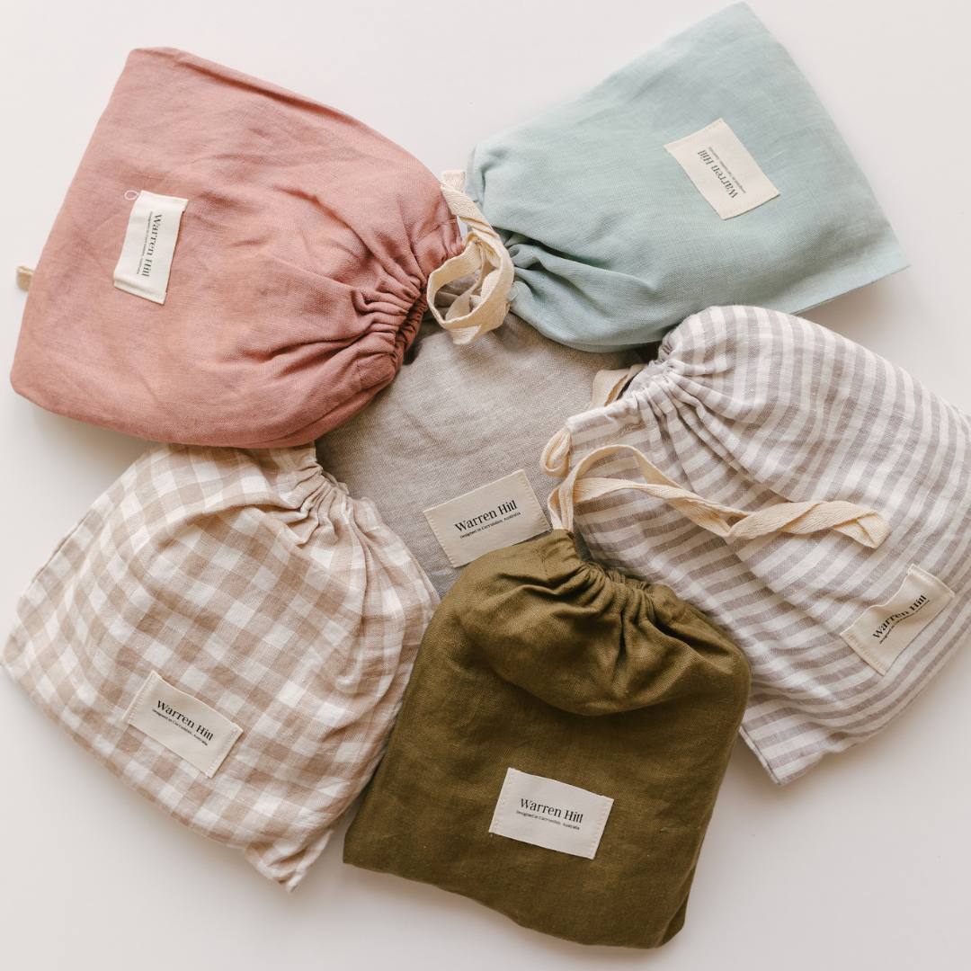 A set of Warren Hill french linen fitted cot sheets in different colors.