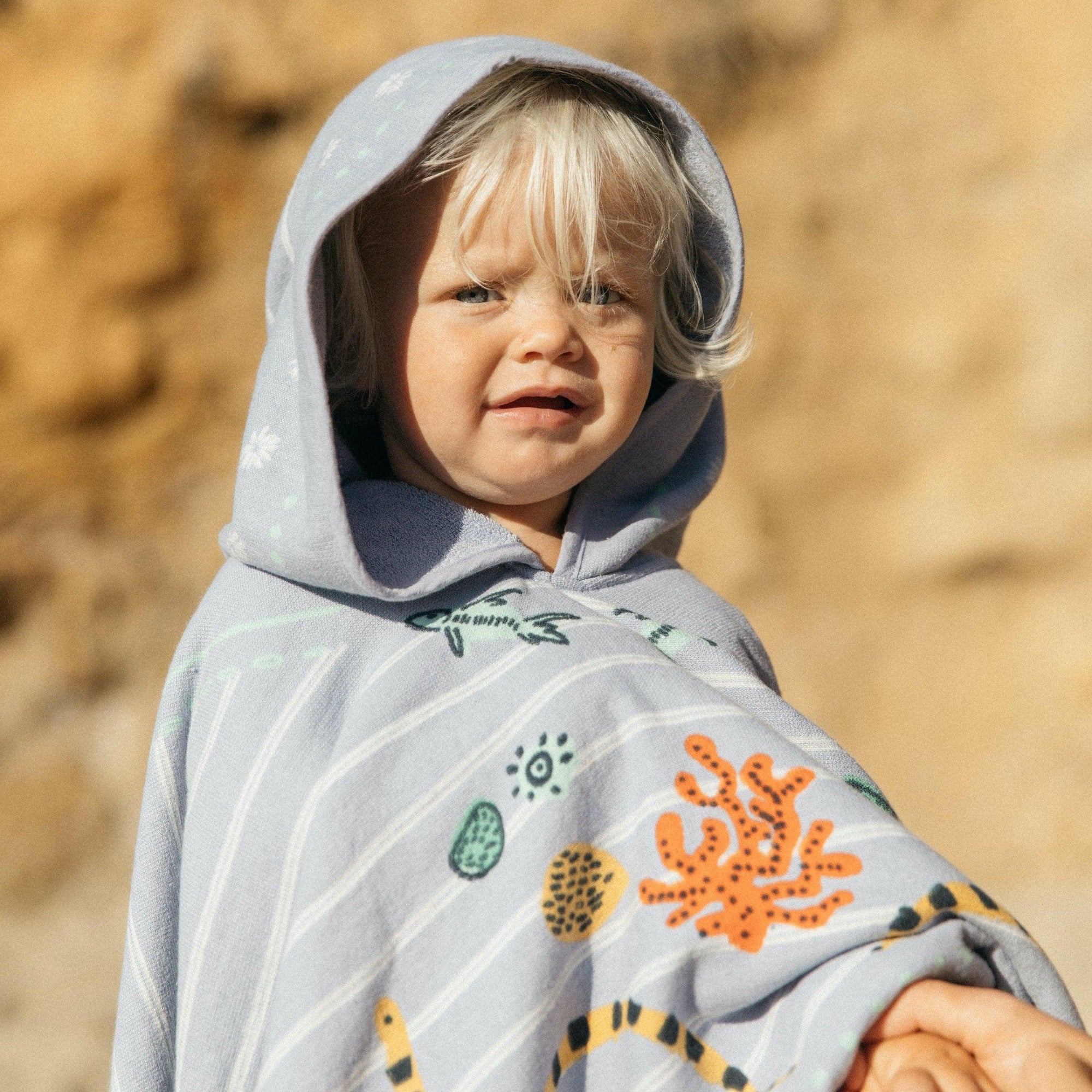 Made from 100% soft cotton, finished with a hood and the signature eyelash fringing, our Buccaneer Petite Poncho features hand illustrated sea creatures to keep your little one's imagination running wild.