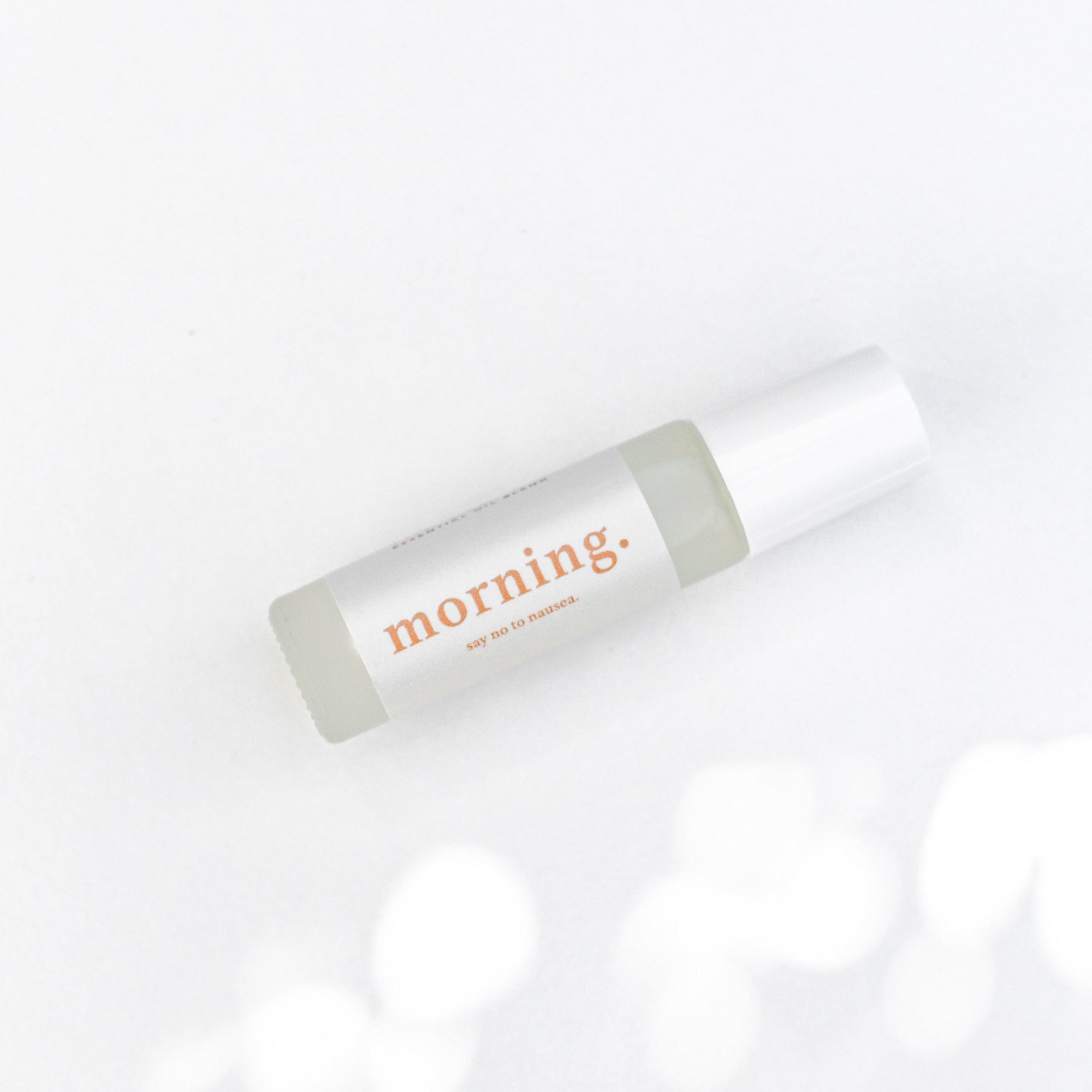 A bottle of Clē Naturals morning essential oil on a white surface.